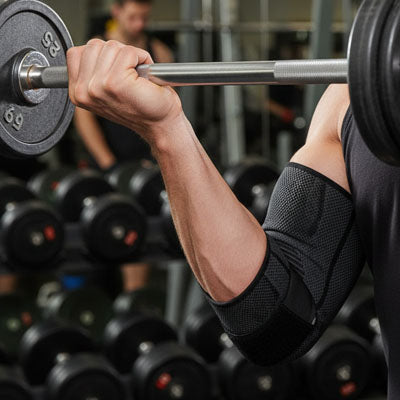 Manchon de compression coude noir porté pendant un entraînement de musculation avec haltère