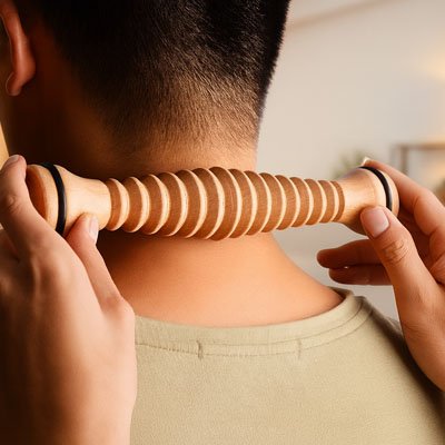 Utilisation du rouleau de massage en bois sur la nuque et les cervicales pour soulager les douleurs et raideurs