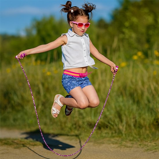 Fille avec lunette faisant de la corde a sauter en extérieur 